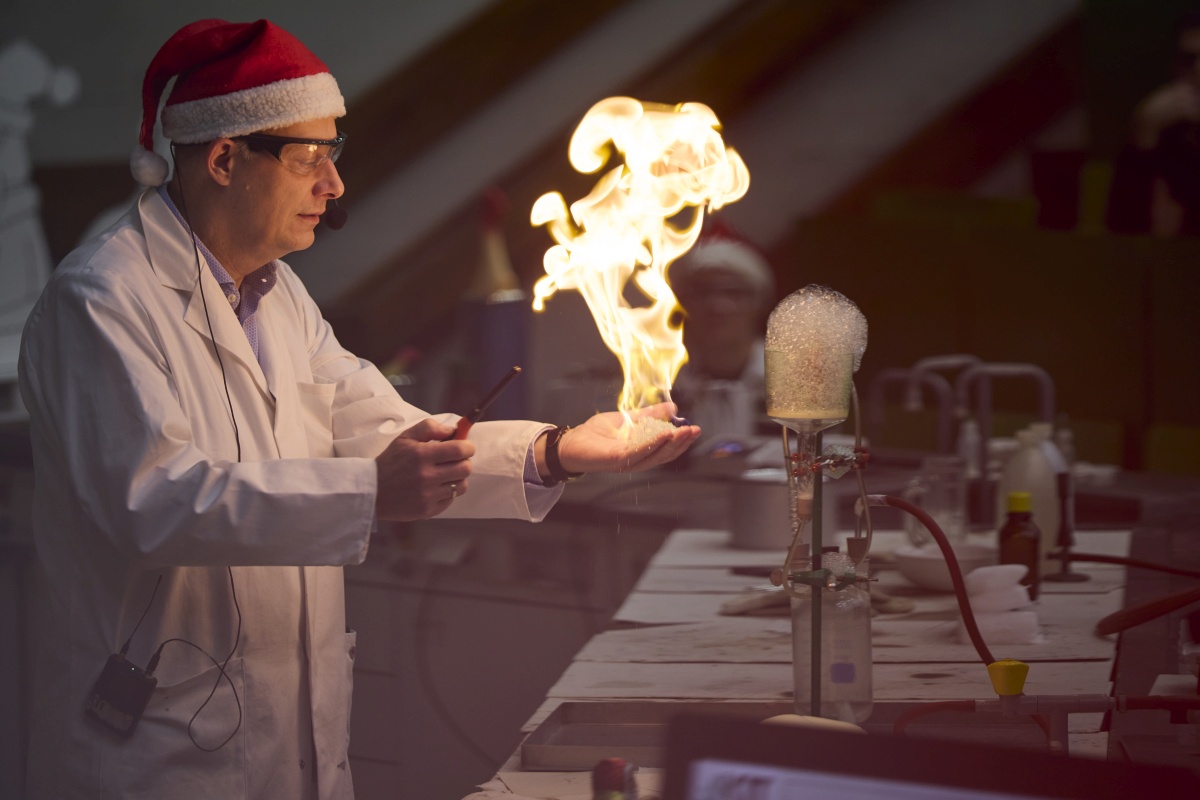 Professor Roesky balanciert eine Flamme auf seiner Hand.