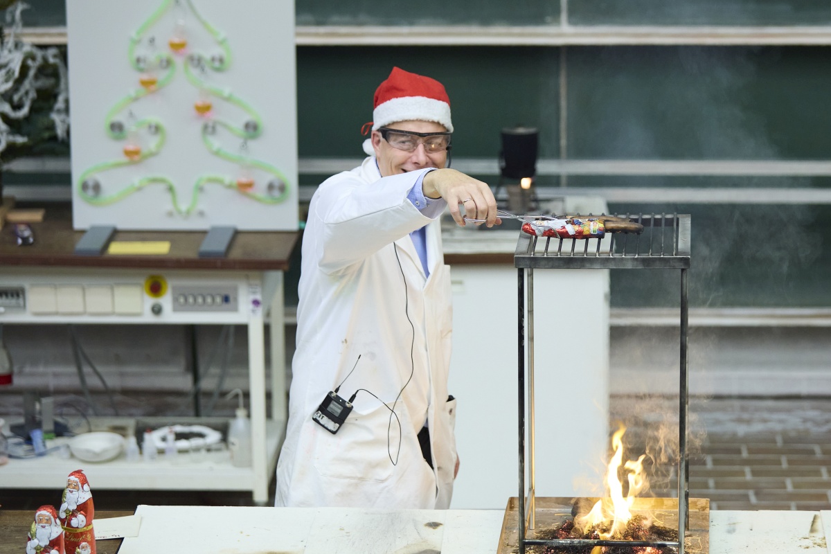 Professor Roesky wendet Weihnachtsmänner über einer Flamme. 