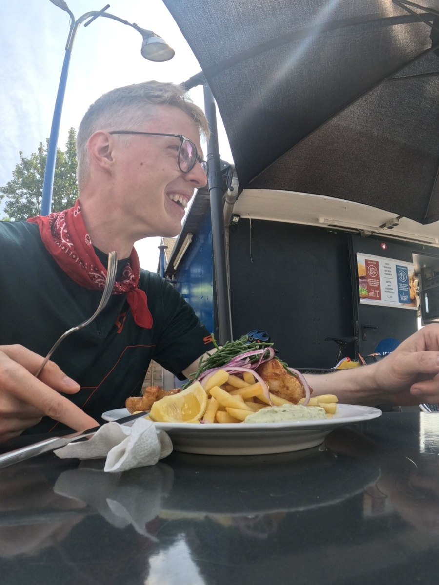 Arnd Hanisch im Gespräch am Imbisstand mit Pommes und Fisch.