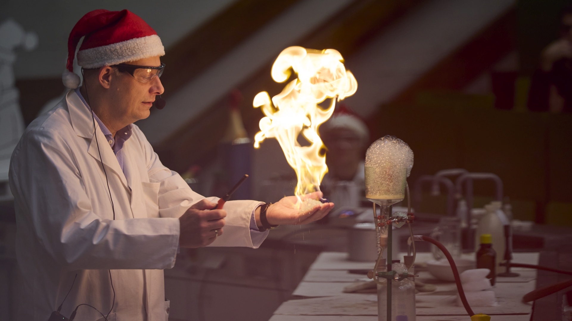 Professor Roesky balanciert eine Flamme auf seiner Hand.